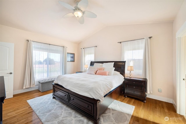 bedroom with ceiling fan, vaulted ceiling, and light wood-type flooring