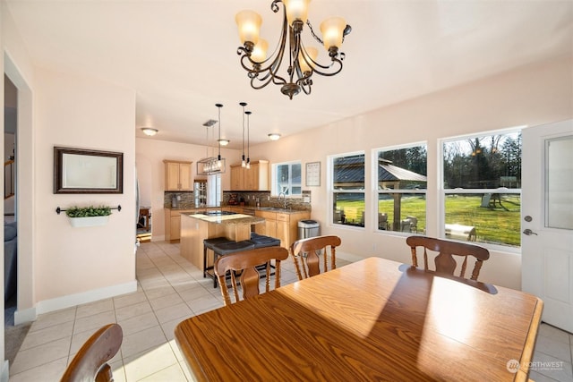 tiled dining space featuring sink and a chandelier