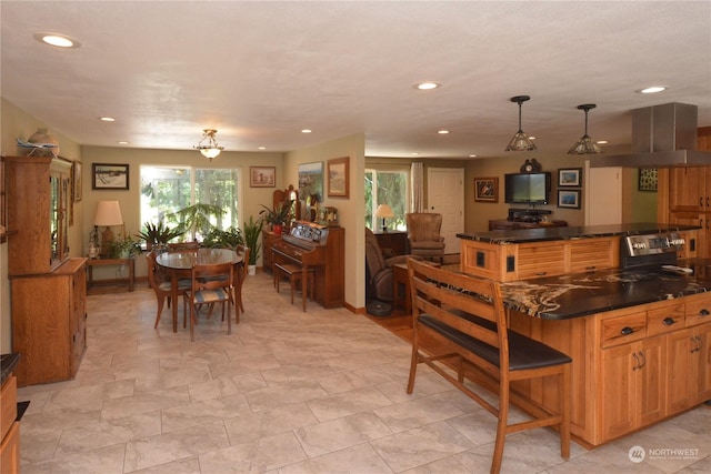 kitchen featuring stainless steel electric range, a center island, extractor fan, a kitchen bar, and decorative light fixtures