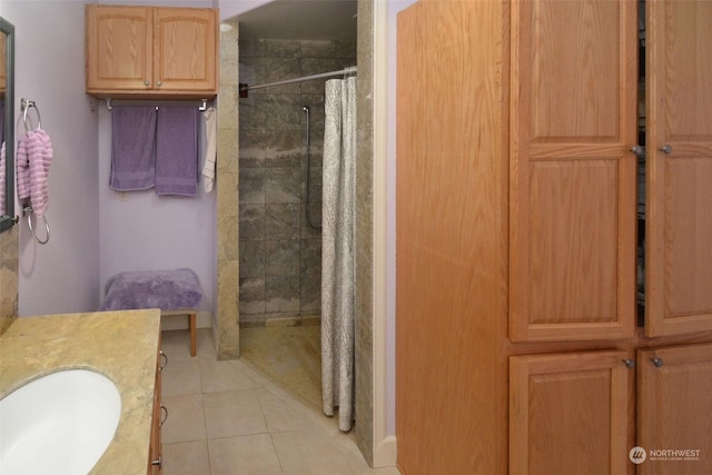 bathroom with tile patterned flooring, vanity, and walk in shower