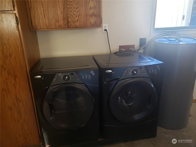 laundry room with water heater, washer and clothes dryer, cabinets, and light tile patterned flooring