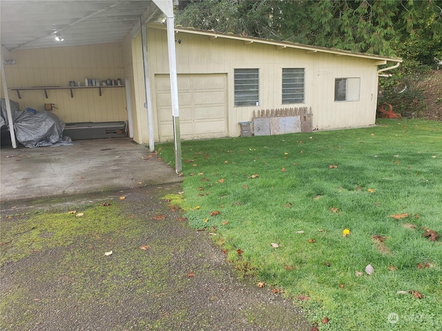 garage featuring a carport and a yard