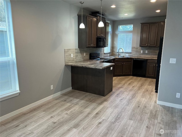 kitchen with sink, dark brown cabinetry, light stone counters, black appliances, and light wood-type flooring