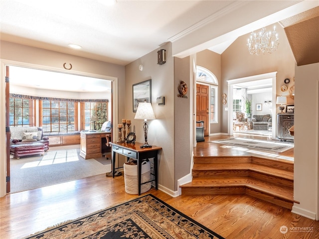 foyer entrance with hardwood / wood-style floors and a chandelier