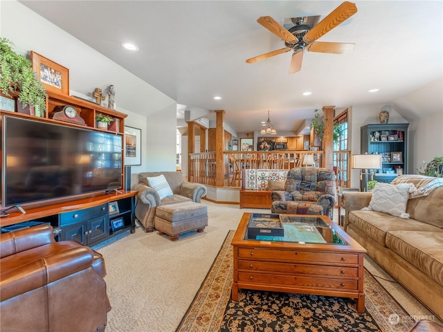 living room with vaulted ceiling and ceiling fan with notable chandelier