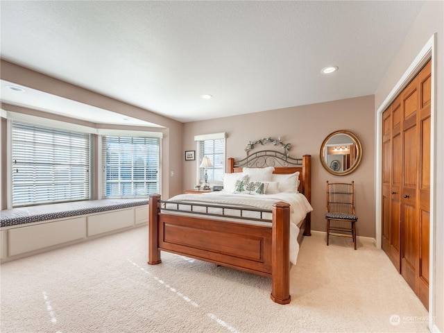 bedroom with light carpet and a closet