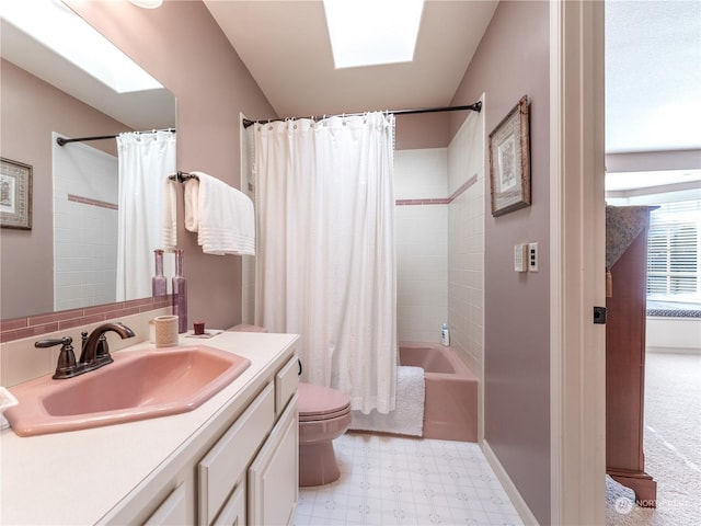 full bathroom featuring vanity, toilet, a skylight, and shower / bath combo