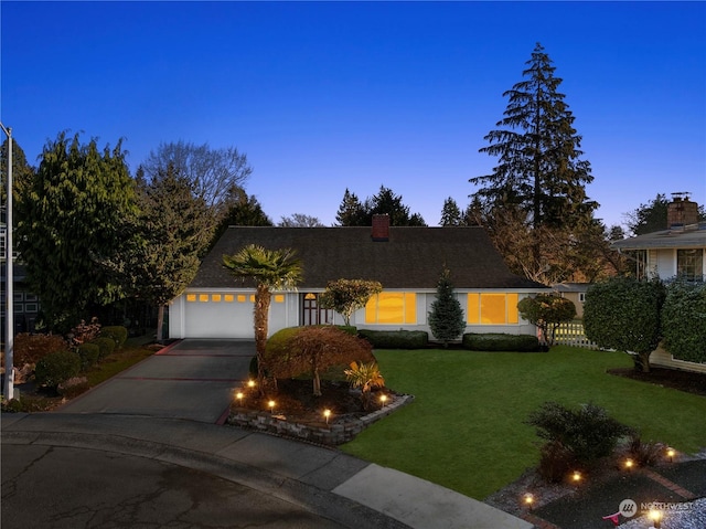 view of front of home with a garage and a yard