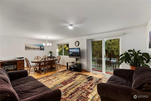 living room with a notable chandelier and light hardwood / wood-style floors