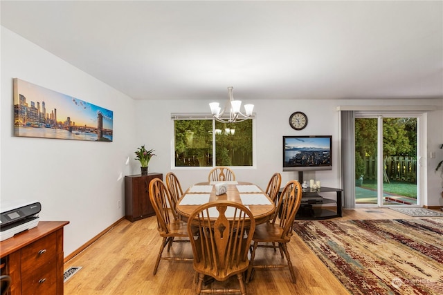 dining area with an inviting chandelier and light hardwood / wood-style floors