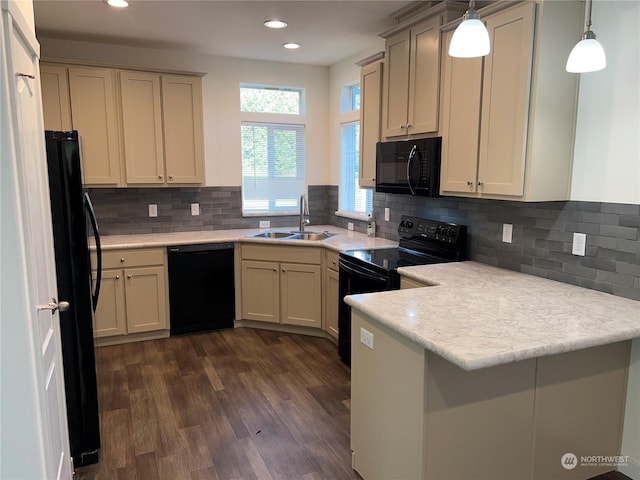 kitchen featuring sink, dark hardwood / wood-style floors, black appliances, decorative light fixtures, and kitchen peninsula