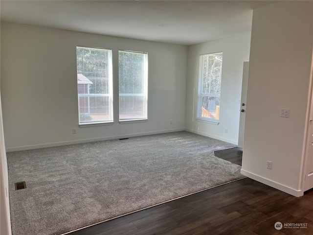 unfurnished room with dark colored carpet