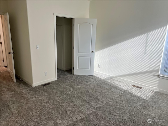 unfurnished bedroom with dark carpet