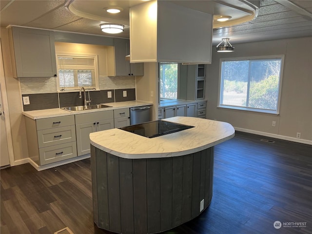 kitchen with pendant lighting, sink, dark hardwood / wood-style floors, black electric cooktop, and stainless steel dishwasher