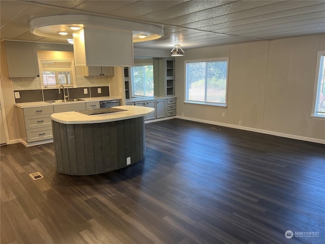 kitchen featuring sink, white cabinetry, a center island, dark hardwood / wood-style flooring, and backsplash