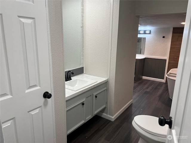 bathroom featuring hardwood / wood-style flooring, vanity, and toilet