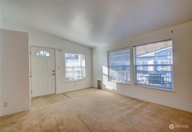 carpeted entrance foyer with lofted ceiling