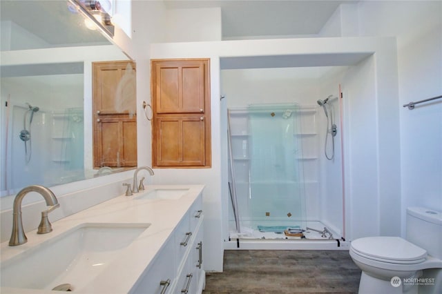 bathroom featuring walk in shower, vanity, toilet, and hardwood / wood-style floors