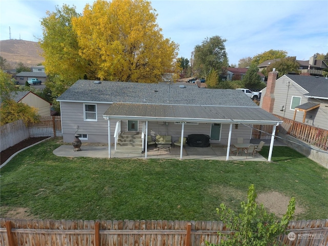 rear view of house featuring a lawn and a patio