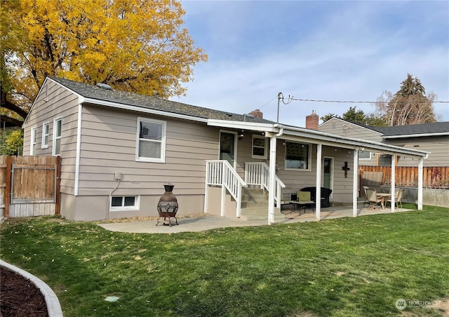 back of house with a yard, a fire pit, and a patio