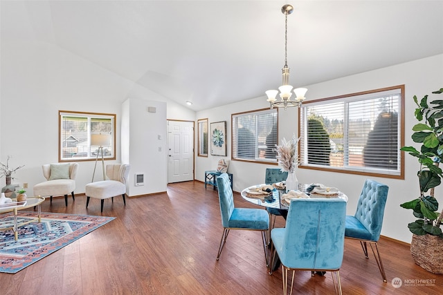 dining room with lofted ceiling, a notable chandelier, and hardwood / wood-style flooring