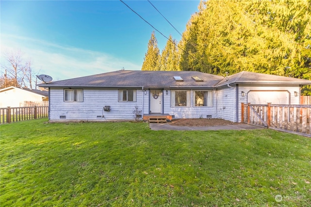 back of property with a garage and a lawn