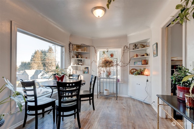 dining area with built in features and light wood-type flooring