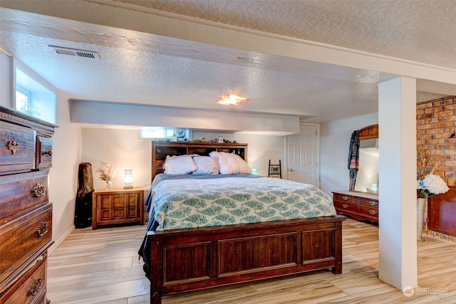 bedroom with a textured ceiling and light wood-type flooring