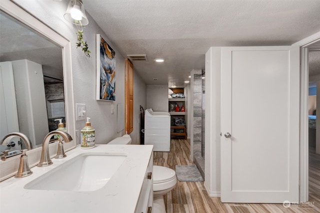 bathroom with vanity, hardwood / wood-style flooring, toilet, and a textured ceiling