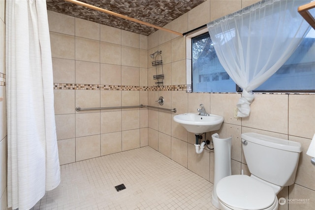 bathroom with sink, curtained shower, tile patterned floors, and toilet