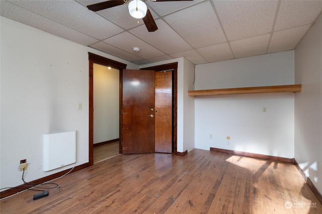 unfurnished bedroom featuring hardwood / wood-style floors, a paneled ceiling, and ceiling fan