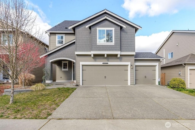 craftsman-style home featuring concrete driveway and a shingled roof