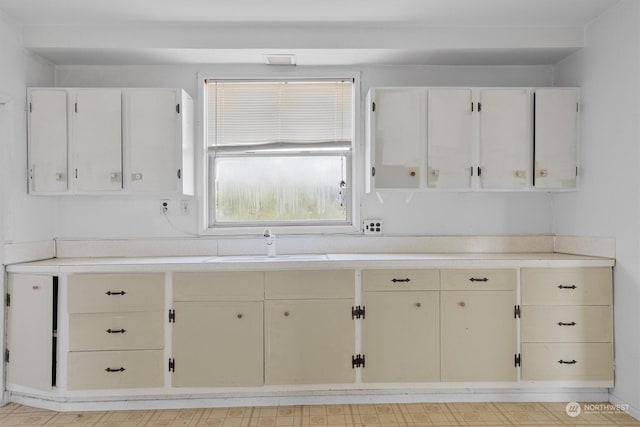 kitchen with white cabinetry and sink