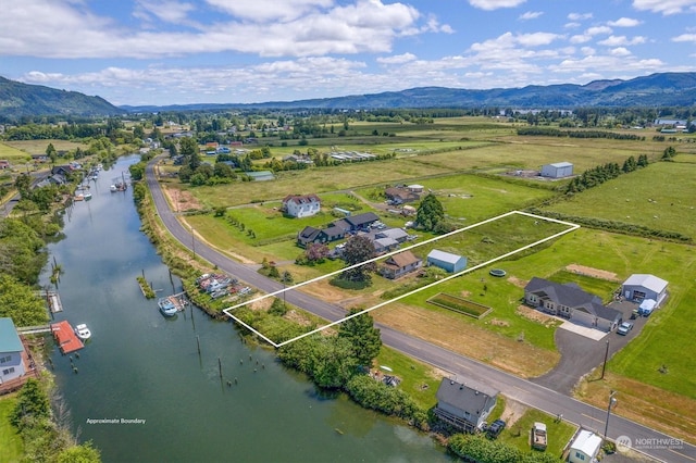 birds eye view of property featuring a water and mountain view and a rural view