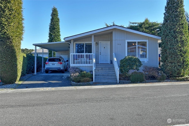 manufactured / mobile home featuring a carport and a porch