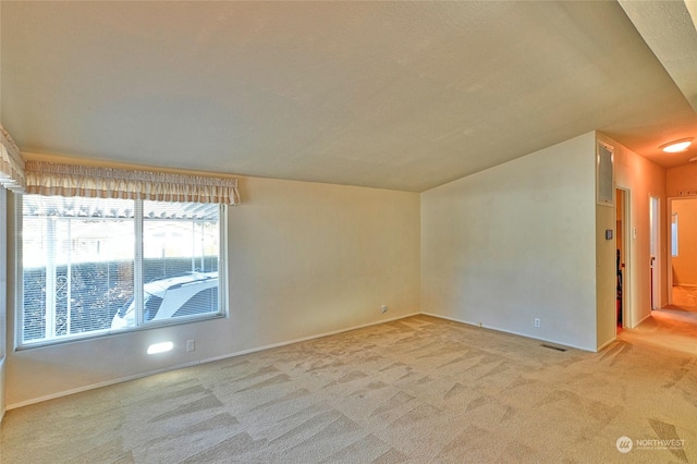 carpeted spare room featuring lofted ceiling