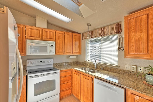 kitchen with vaulted ceiling, pendant lighting, sink, light stone countertops, and white appliances