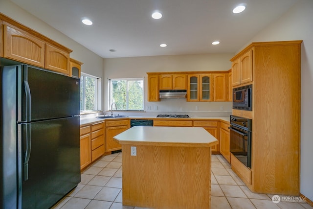 kitchen featuring sink, light tile patterned flooring, black appliances, and a kitchen island