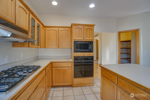 kitchen featuring light tile patterned flooring, light brown cabinetry, and black appliances