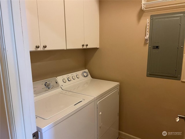 clothes washing area with washer and clothes dryer, electric panel, and cabinets