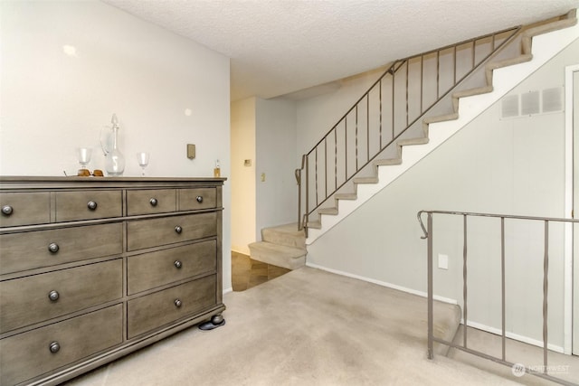 interior space featuring a textured ceiling and carpet flooring