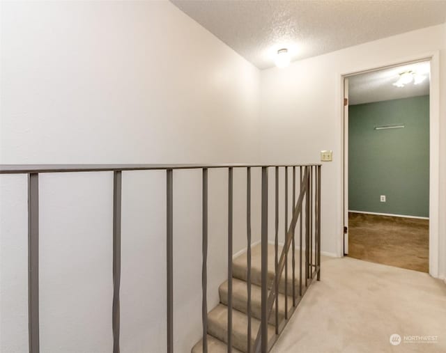 stairs featuring carpet floors and a textured ceiling