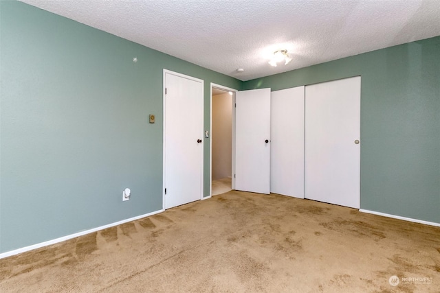 unfurnished bedroom featuring a closet, carpet flooring, and a textured ceiling