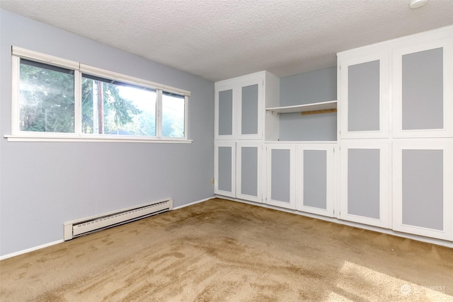 spare room featuring a baseboard radiator, light colored carpet, and a textured ceiling