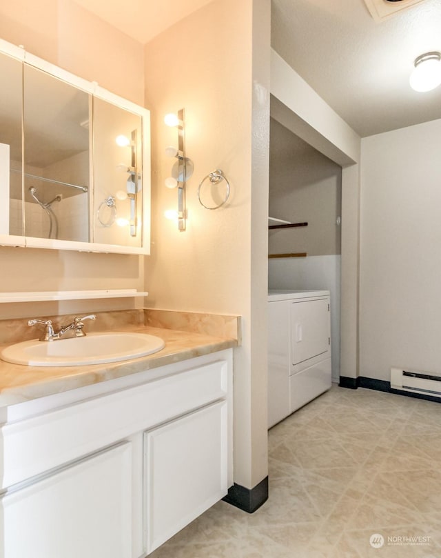 bathroom with vanity, a baseboard heating unit, and washing machine and dryer