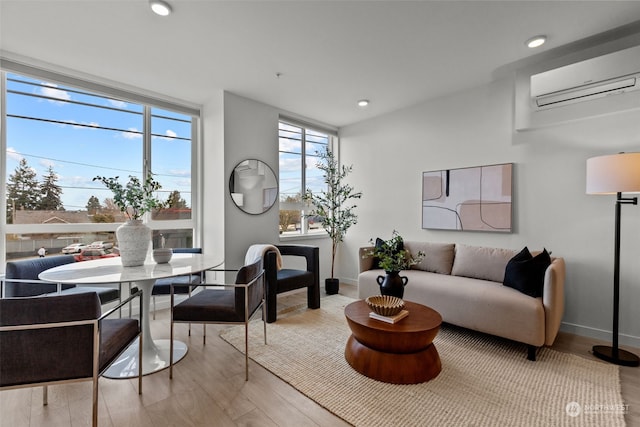 living room featuring a wall unit AC and light wood-type flooring