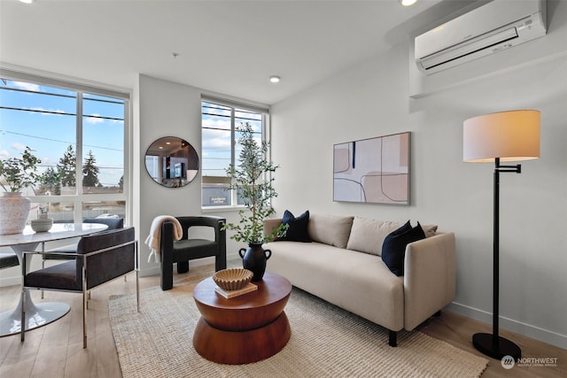 living room with light hardwood / wood-style flooring and an AC wall unit