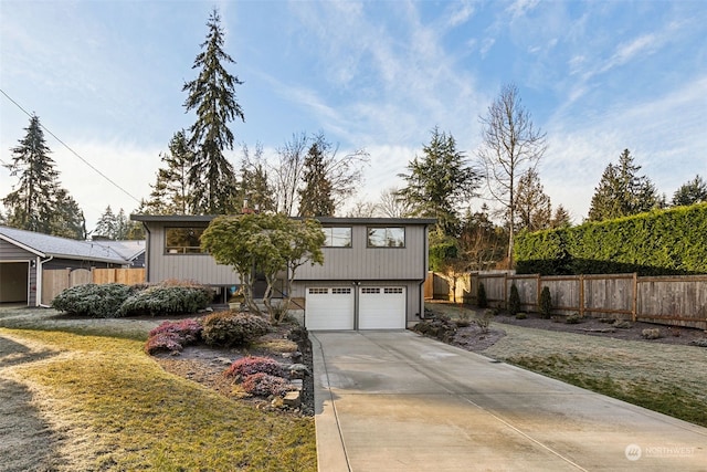 bi-level home featuring a garage and a front lawn