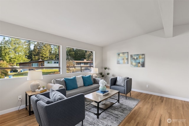 living room with lofted ceiling with beams and hardwood / wood-style floors