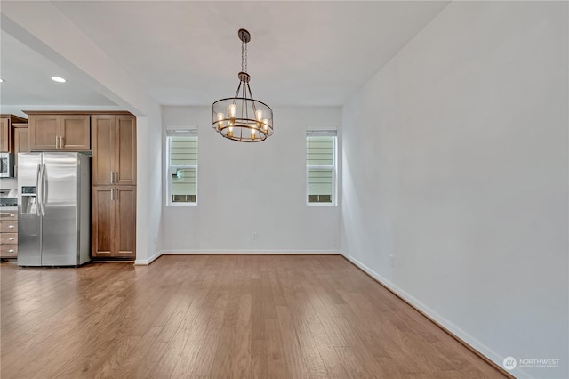 kitchen featuring an inviting chandelier, hardwood / wood-style flooring, decorative light fixtures, and appliances with stainless steel finishes